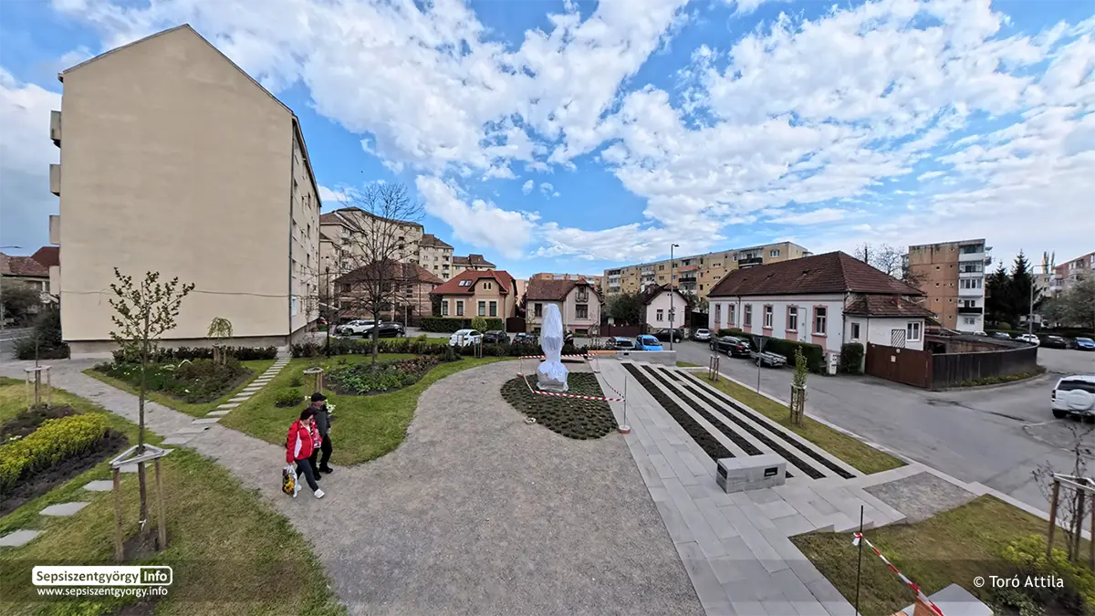Panorámakép a sepsiszentgyörgyi Petőfi parkról, középpontban a lepelbe burkolt Petőfi-szoborral és a modern parkosított környezettel.